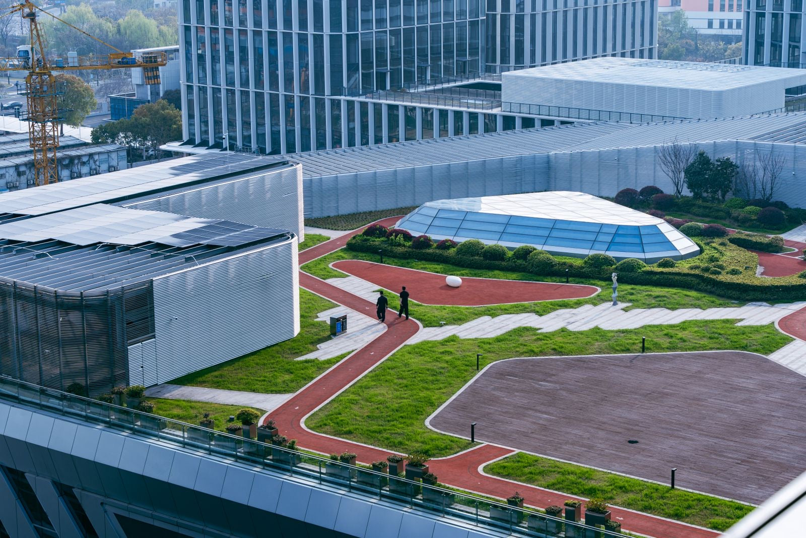 Modern building complex with solar panels and a green roof, reflecting LEED v5 impact areas