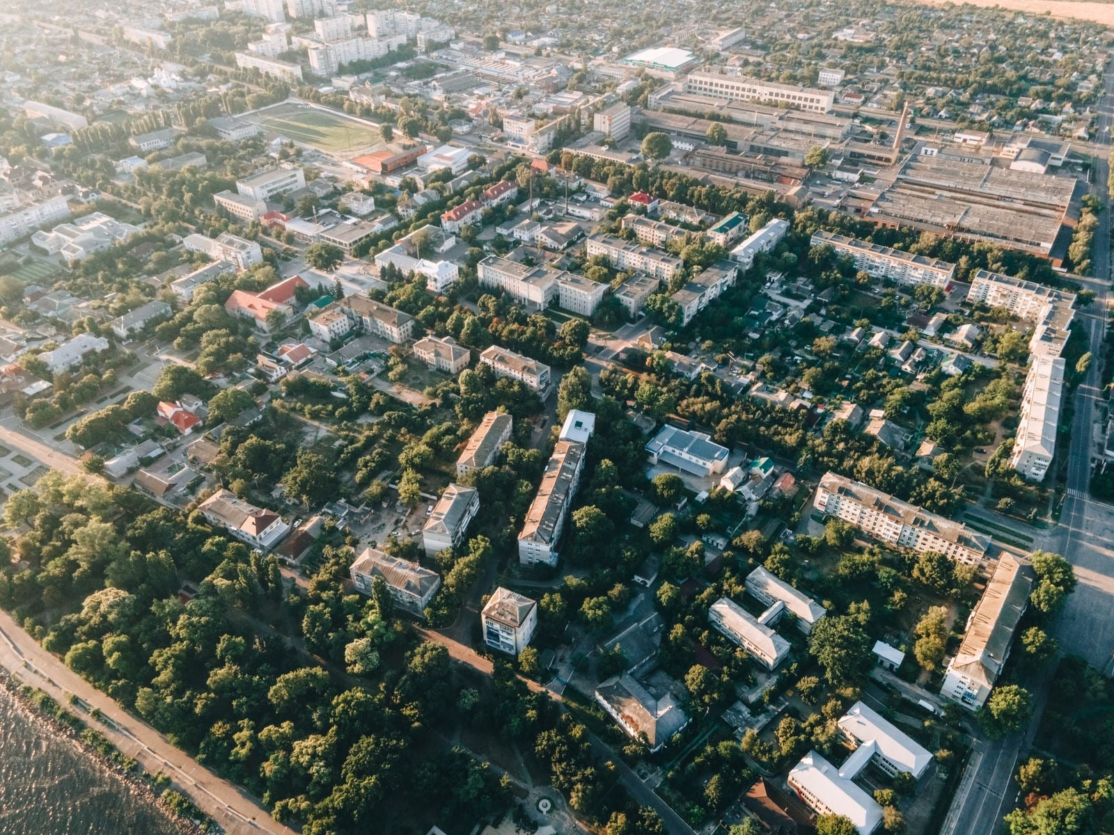 Aerial view of a dense, green urban neighborhood with residential buildings and tree cover, the scale LEED ND certifies